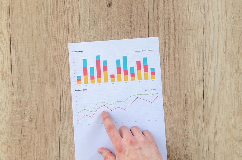 Investor analyzing non-performing notes strategy on a laptop with financial charts and documents.