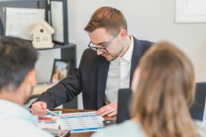 Business professional reviewing loan default recovery options with clients during a financial consultation.