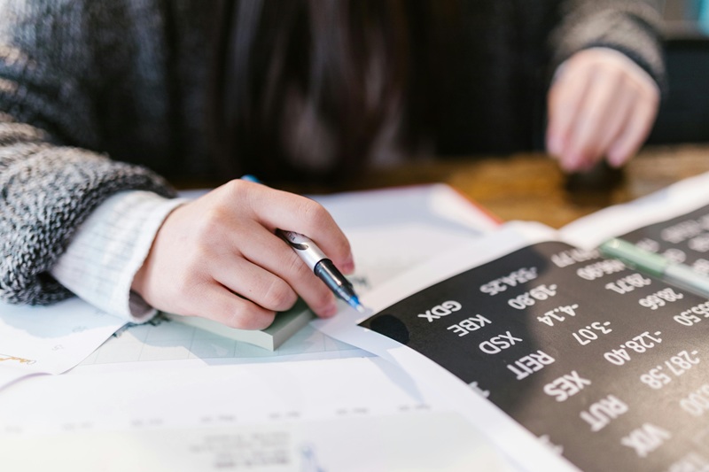 Person reviewing financial documents and notes, representing how real estate note investing can generate steady passive income without property management.