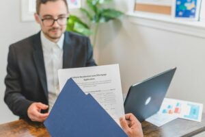Lender reviewing residential mortgage loan application during borrower meeting in office setting