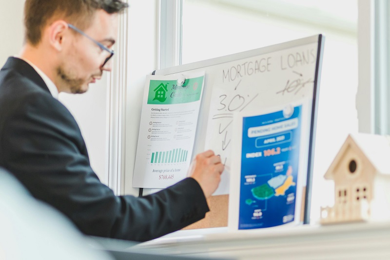 Real estate investor reviewing mortgage loan charts and cash flow analysis for buying discounted mortgage notes