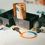 Miniature houses with euro banknotes and financial charts illustrating real estate investing, mortgage notes, and the impact of interest rates on returns and cash flow.