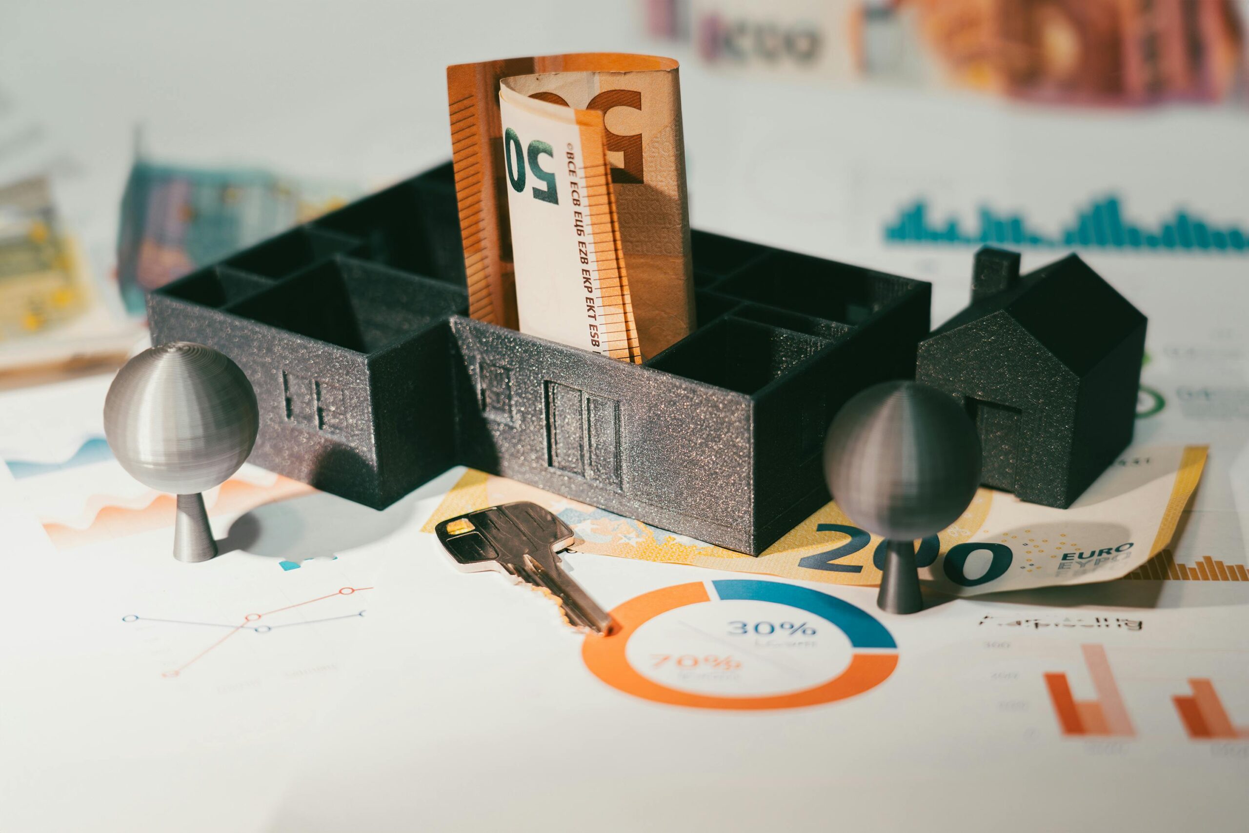Miniature houses with euro banknotes and financial charts illustrating real estate investing, mortgage notes, and the impact of interest rates on returns and cash flow.